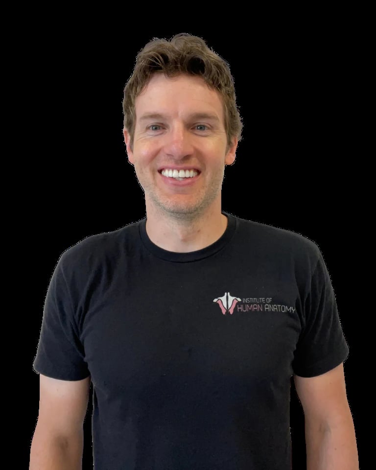Smiling man with light brown hair wearing a black t-shirt with a logo on the chest against a black background